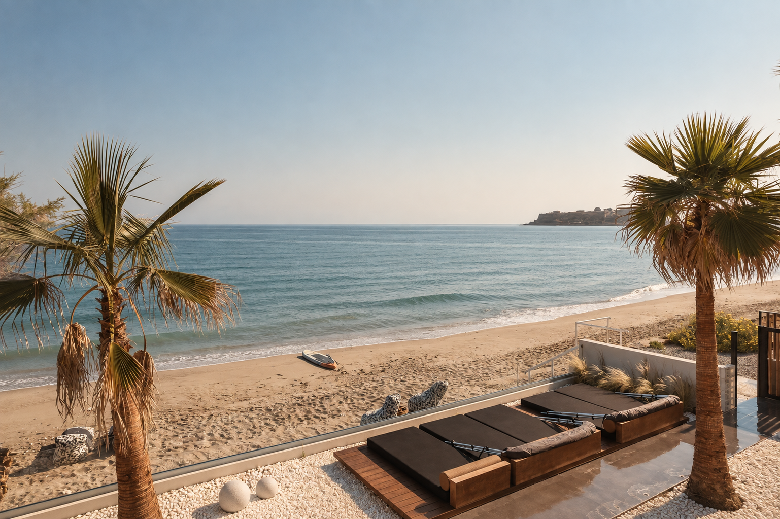 Casa Negro beachfront terrace with daybeds, palms and the Aegean